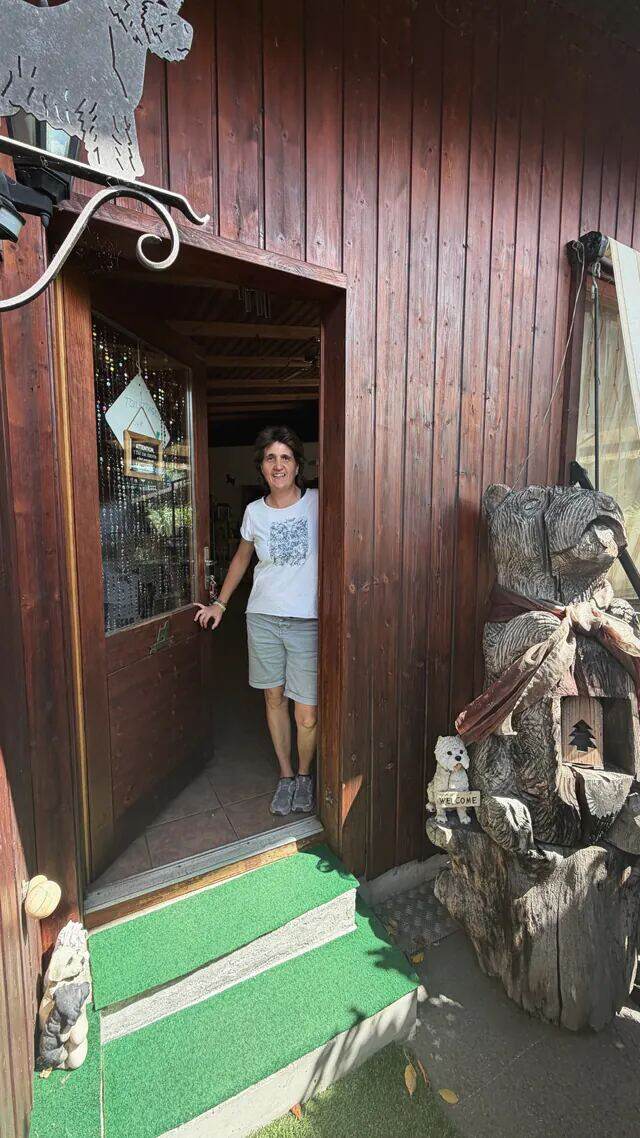 Monique Perrod, souriante, dans l'embrasure de la porte en bois.