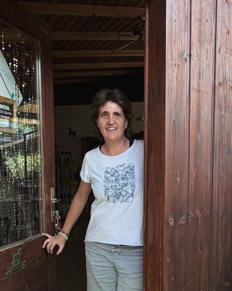 Monique Perrod, souriante, dans l'embrasure de la porte en bois du salon.